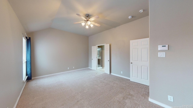 spare room featuring lofted ceiling, light colored carpet, and ceiling fan