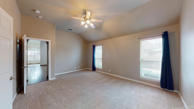 carpeted spare room featuring ceiling fan and vaulted ceiling