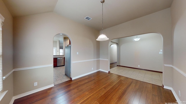 unfurnished room with hardwood / wood-style floors and lofted ceiling