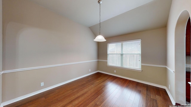 spare room with dark hardwood / wood-style flooring and lofted ceiling