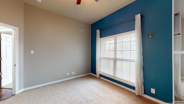 carpeted spare room featuring ceiling fan