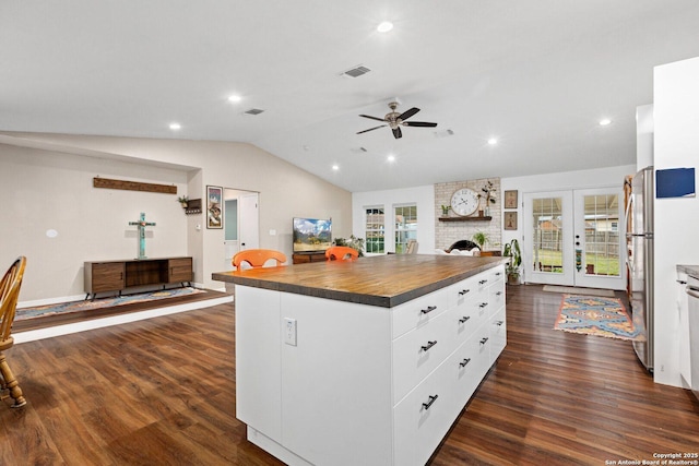 kitchen with a healthy amount of sunlight, white cabinetry, butcher block counters, and a center island