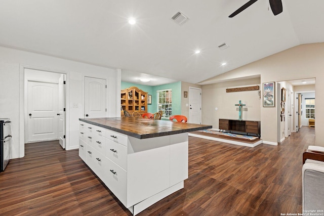 kitchen featuring ceiling fan, dark hardwood / wood-style floors, lofted ceiling, white cabinets, and a center island