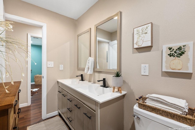 bathroom featuring toilet, vanity, and hardwood / wood-style flooring