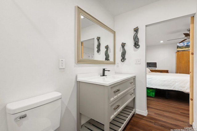 bathroom featuring ceiling fan, vanity, toilet, and hardwood / wood-style floors