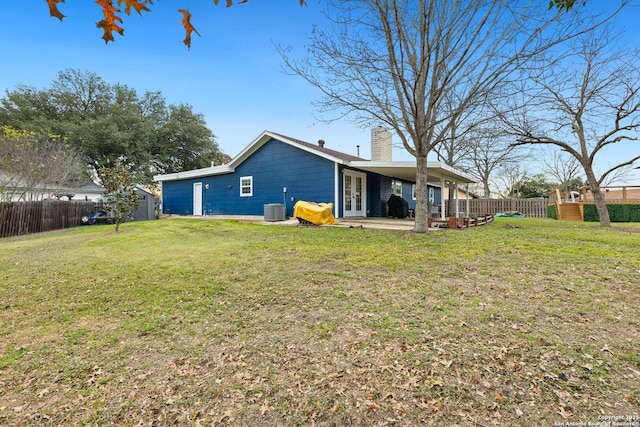 back of property featuring cooling unit, a storage unit, a patio, and a yard