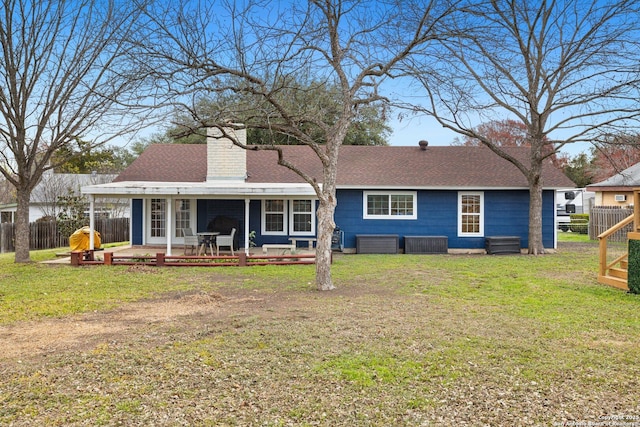 rear view of property featuring a yard