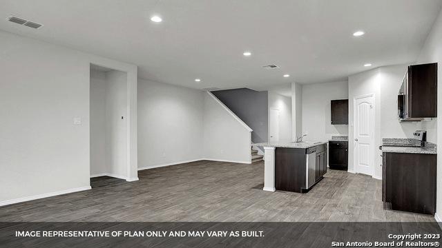 kitchen with wood-type flooring, dark brown cabinets, and a kitchen island