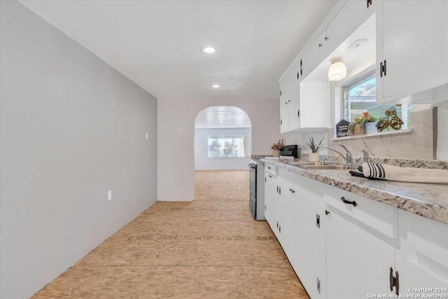 kitchen featuring white cabinetry, range with electric cooktop, and sink