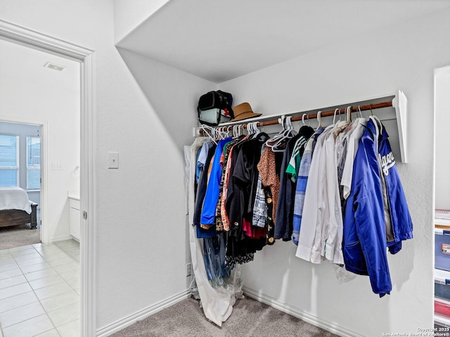 walk in closet featuring light colored carpet