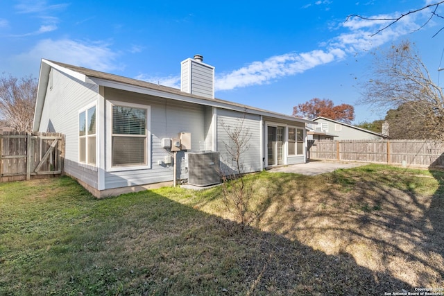 back of house with a patio, a lawn, and central AC