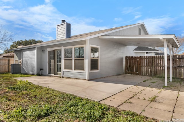 rear view of house with central air condition unit and a carport