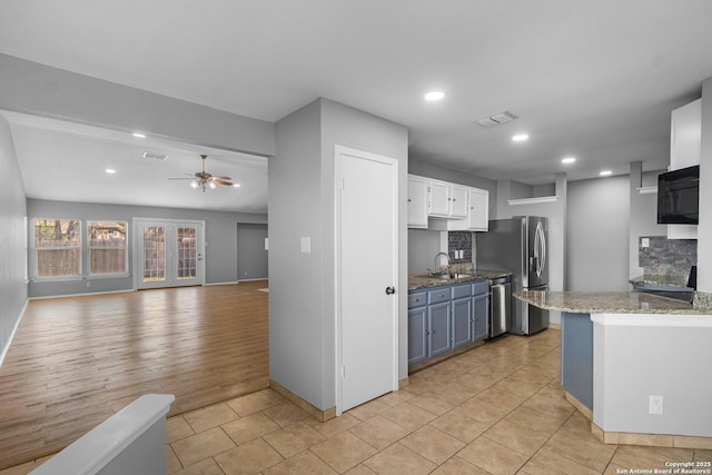 kitchen with ceiling fan, decorative backsplash, white cabinetry, and stainless steel appliances