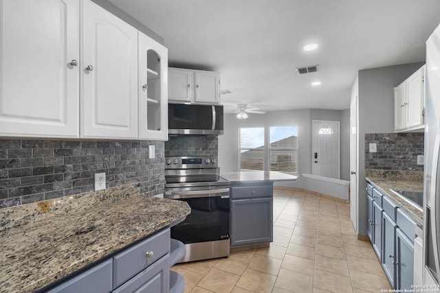 kitchen featuring ceiling fan, backsplash, white cabinetry, appliances with stainless steel finishes, and light tile patterned floors