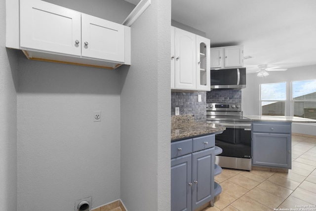 kitchen featuring white cabinetry, stainless steel appliances, decorative backsplash, ceiling fan, and light tile patterned floors