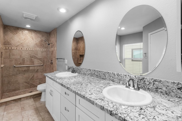 bathroom featuring toilet, vanity, and tiled shower