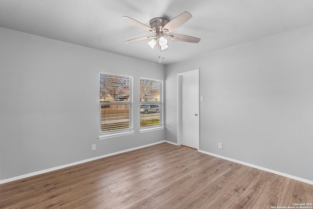 empty room with ceiling fan and hardwood / wood-style flooring