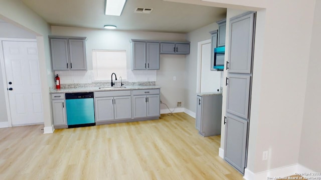 kitchen with dishwasher, sink, backsplash, light stone counters, and light hardwood / wood-style flooring