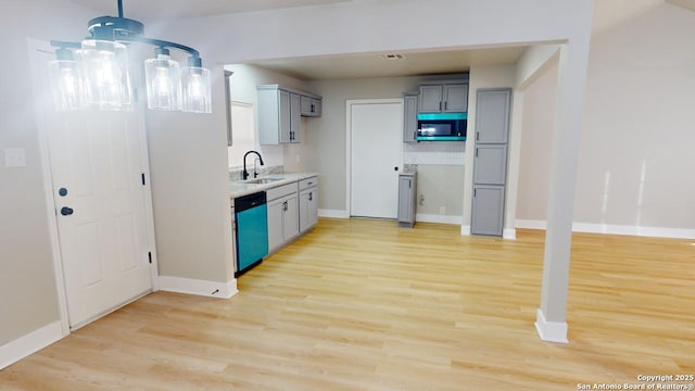 kitchen with light wood-type flooring, dishwasher, sink, and gray cabinetry