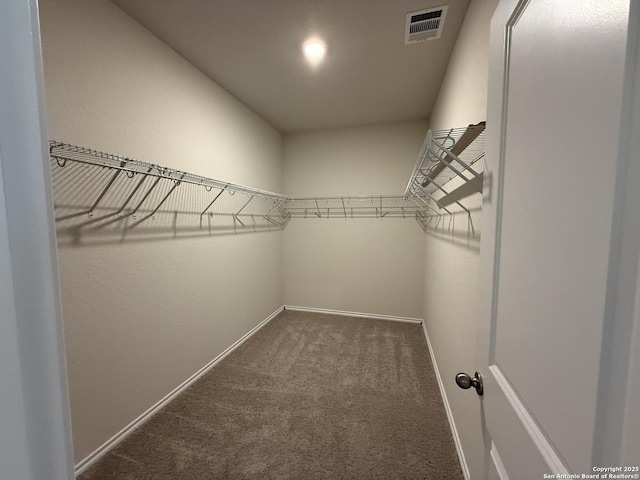 spacious closet featuring dark carpet