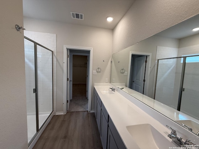 bathroom featuring vanity, wood-type flooring, and walk in shower