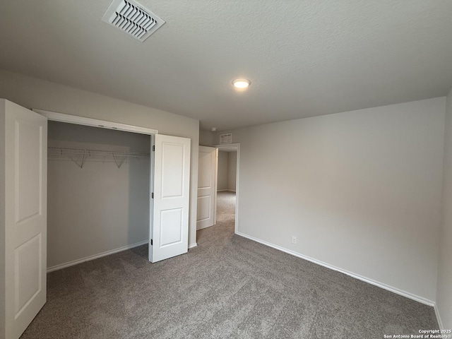 unfurnished bedroom featuring dark carpet, a closet, and a textured ceiling