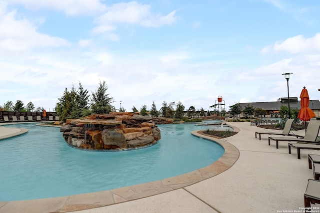 view of pool with pool water feature and a patio area