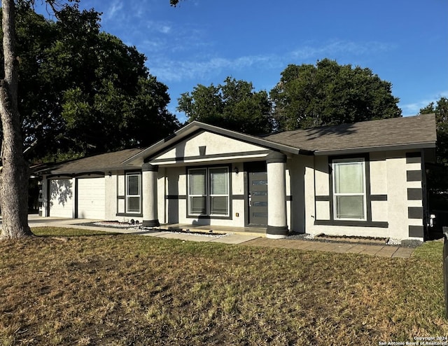 view of front of home with a garage and a front lawn