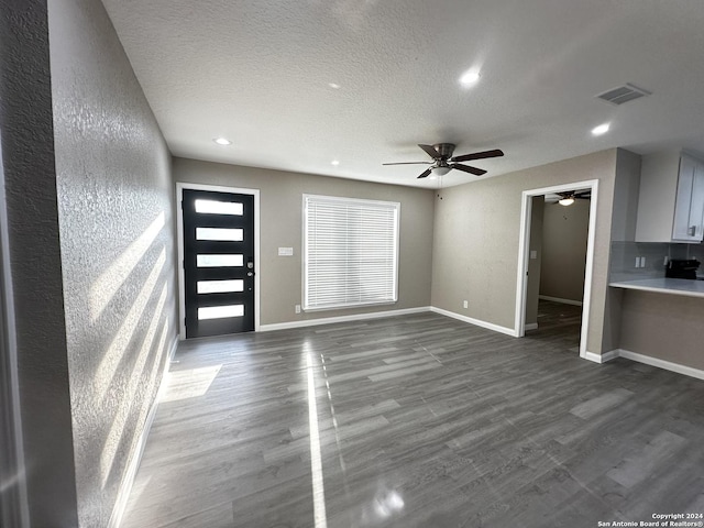 foyer featuring ceiling fan, dark hardwood / wood-style flooring, and a textured ceiling