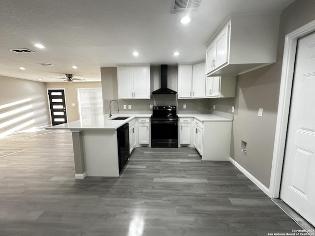 kitchen with white cabinetry, wall chimney range hood, black appliances, and kitchen peninsula