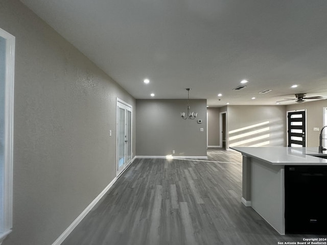 interior space featuring dishwasher, ceiling fan with notable chandelier, pendant lighting, and hardwood / wood-style flooring