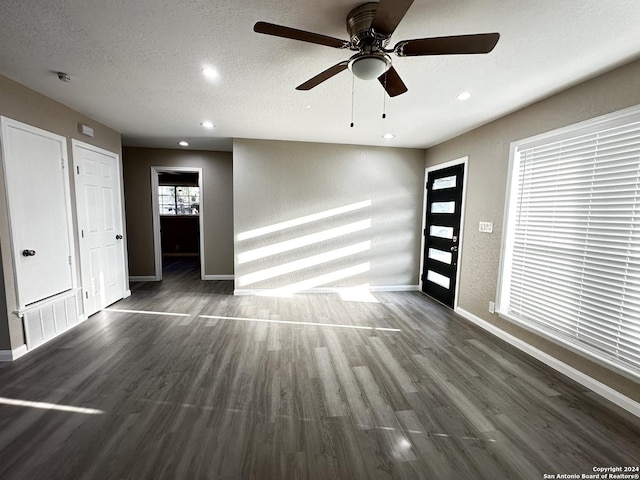 unfurnished room with a textured ceiling, ceiling fan, and dark hardwood / wood-style floors