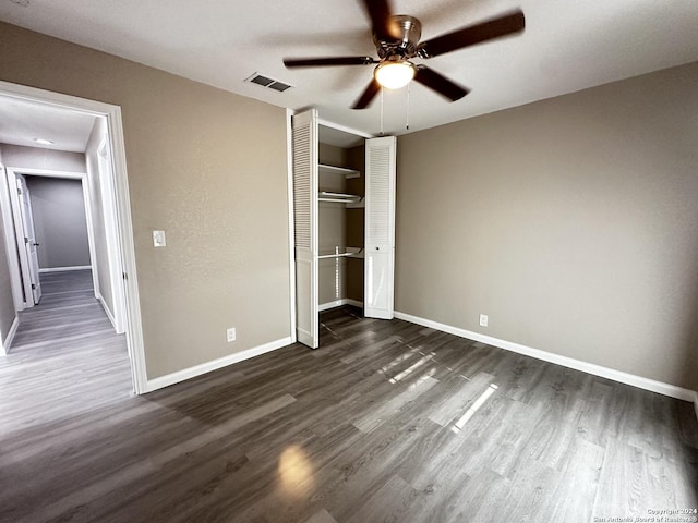 unfurnished bedroom with ceiling fan, dark hardwood / wood-style floors, and a closet