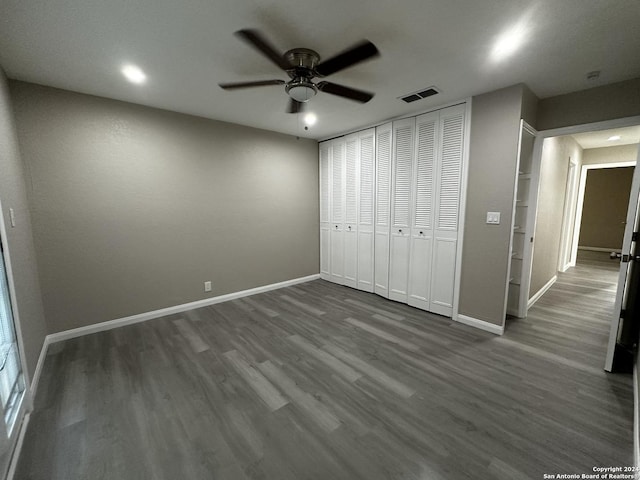 unfurnished bedroom featuring ceiling fan, wood-type flooring, and a closet