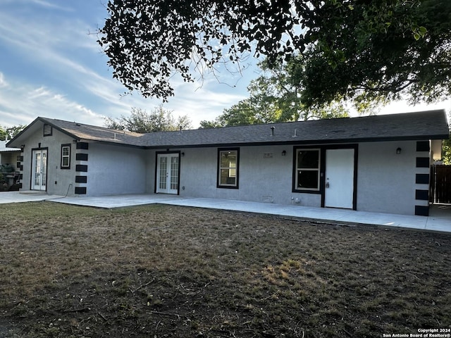 rear view of property with a patio area, french doors, and a yard