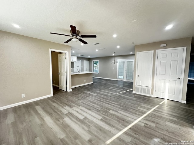 unfurnished living room featuring ceiling fan, sink, a textured ceiling, and dark hardwood / wood-style flooring