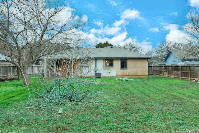 rear view of property featuring a yard and central AC unit