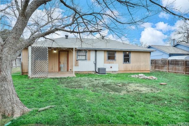 back of property featuring central AC and a yard