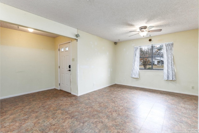 unfurnished room with ceiling fan and a textured ceiling