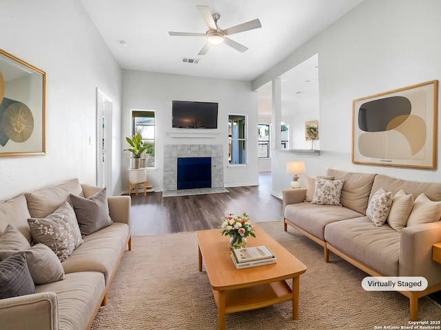 living room with a tile fireplace, hardwood / wood-style flooring, and ceiling fan