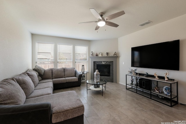 living room with ceiling fan and a fireplace