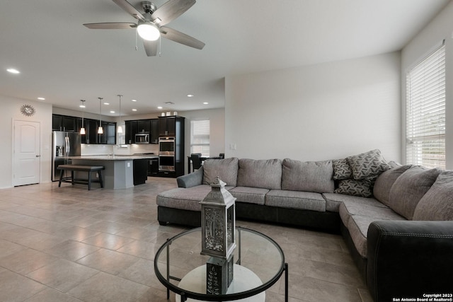 living room with ceiling fan and a wealth of natural light