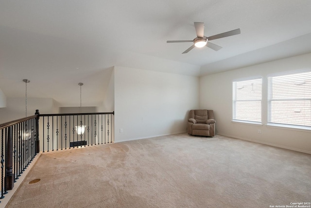 carpeted spare room with vaulted ceiling and ceiling fan