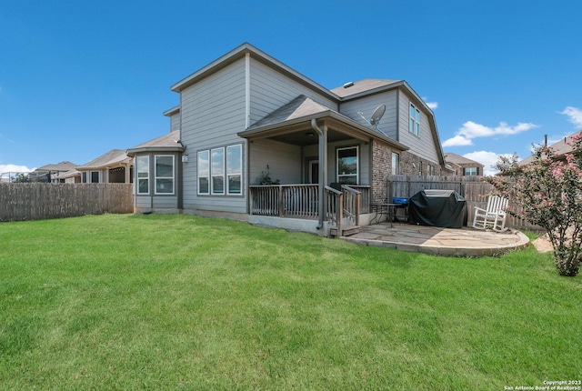 back of property featuring a lawn and a patio