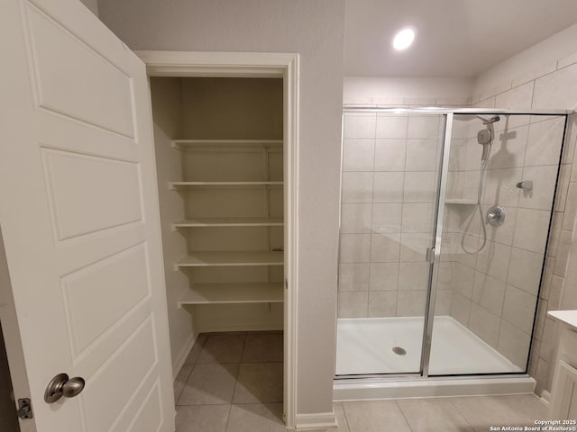 bathroom featuring a shower with shower door and tile patterned flooring