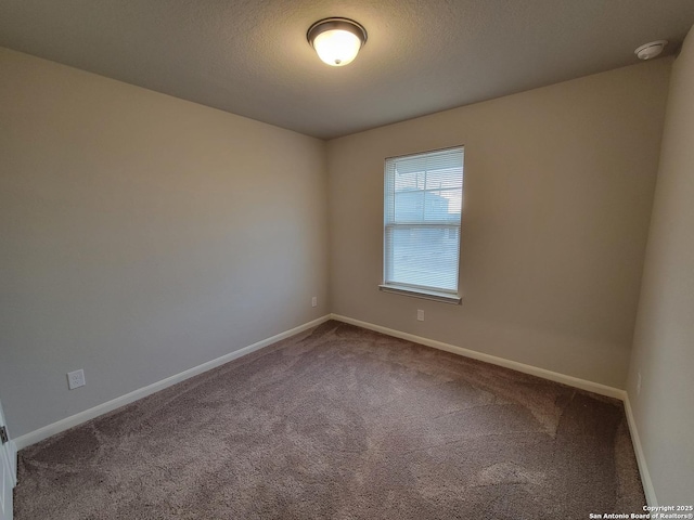 empty room with carpet floors and a textured ceiling