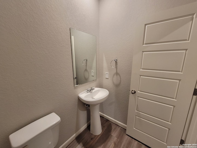 bathroom featuring hardwood / wood-style floors and toilet