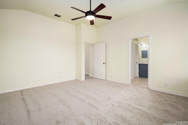 unfurnished bedroom featuring light carpet, lofted ceiling, ceiling fan, and ensuite bathroom