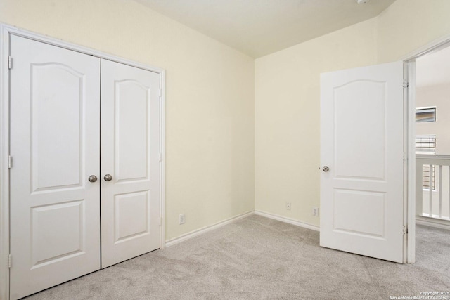 unfurnished bedroom featuring a closet and light carpet