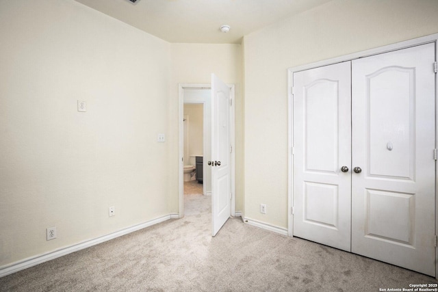 unfurnished bedroom with light carpet and a closet